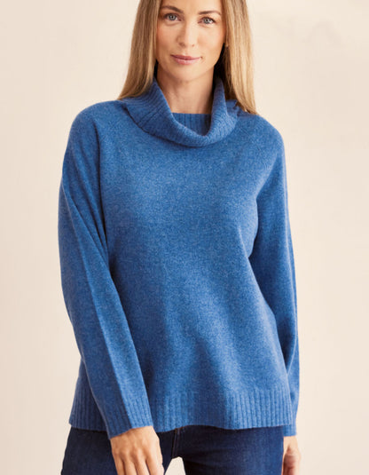 Woman wearing a blue sweater against a beige background