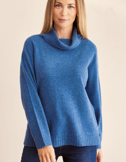 Woman wearing a blue sweater against a beige background