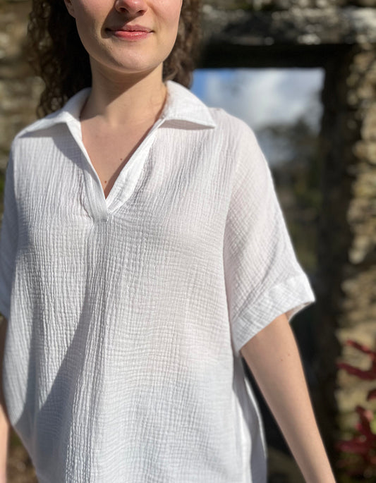 loose fit white over the head shirt with V neckline and collar, loose dropped shoulder with wide elbow length sleeve in gauzy white cotton
