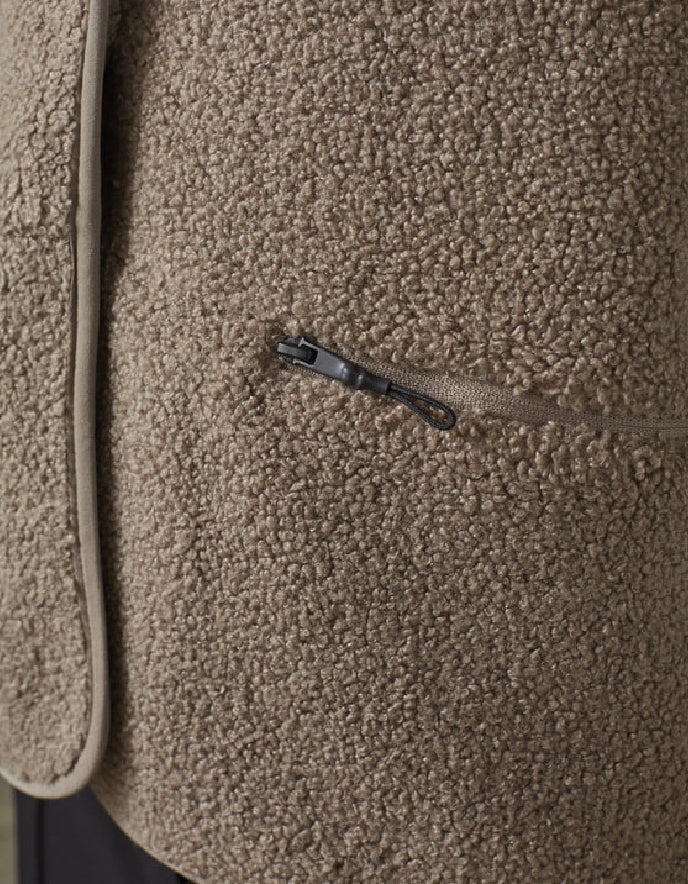 Close-up of a textured brown fabric surface with a zipper