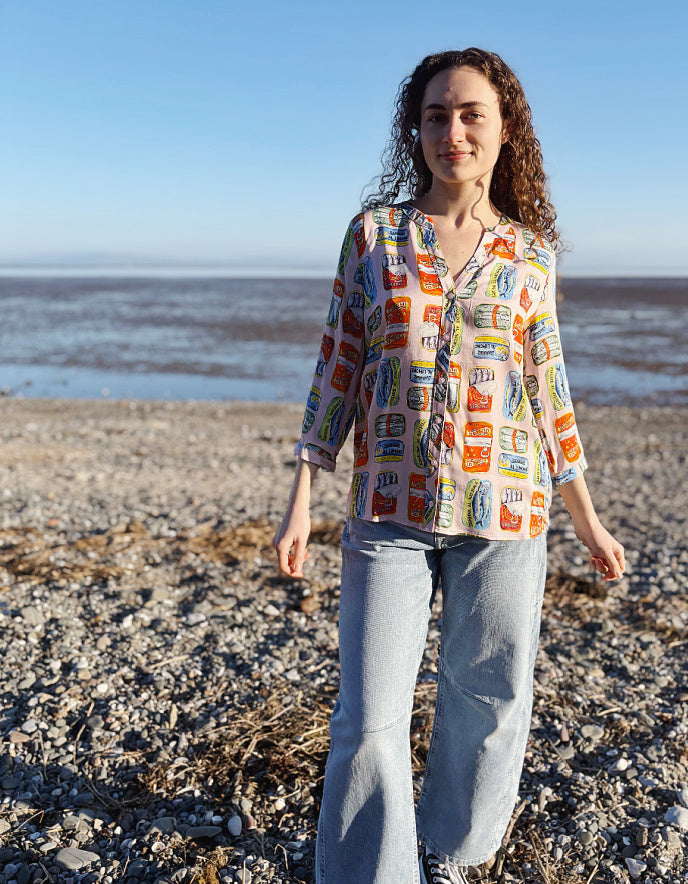 person wearing silk blouse with print of tins of sardines on it