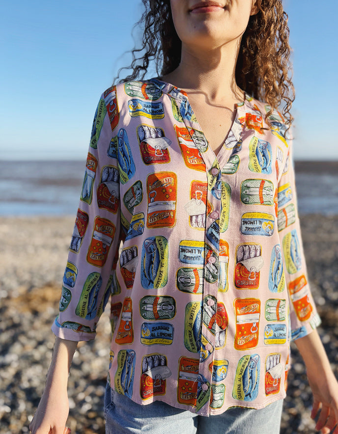 Person wearing a colorful patterned shirt on a beach