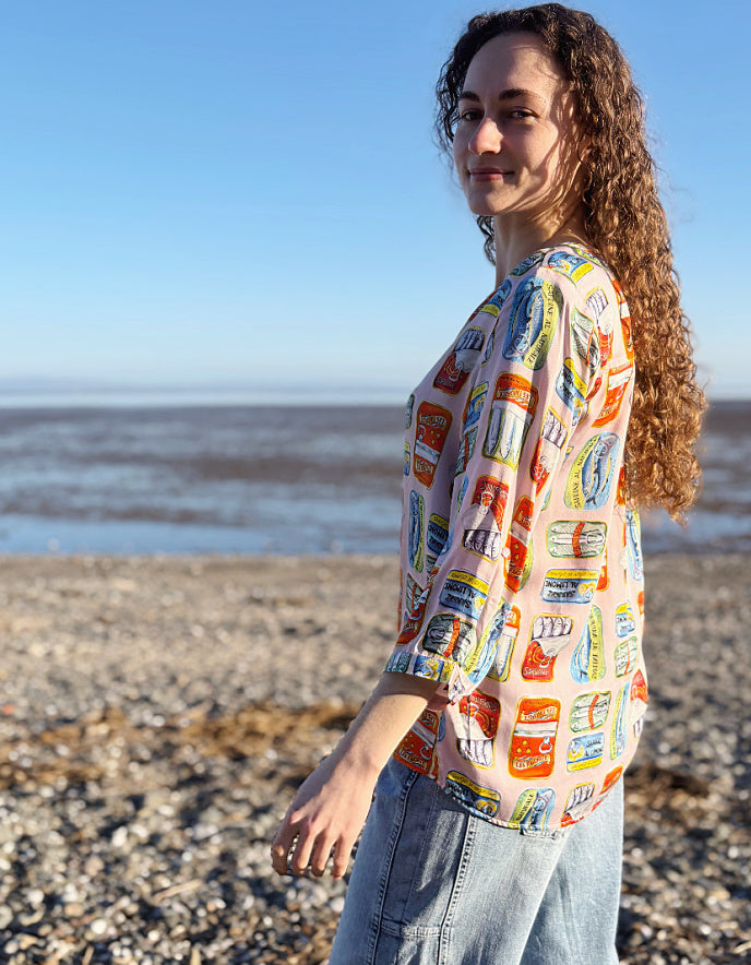 Person wearing a colorful patterned shirt on a beach