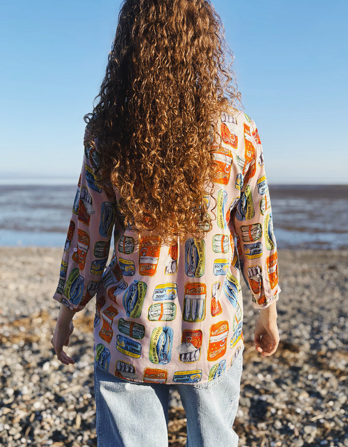 Person wearing a colorful patterned shirt on a beach