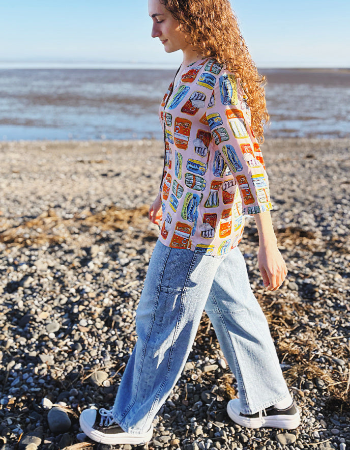 person wearing silk blouse with print of tins of sardines on it