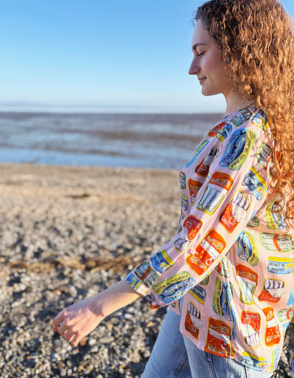 person wearing silk blouse with print of tins of sardines on it