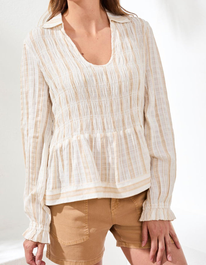 Woman wearing a striped blouse and beige shorts on a white background