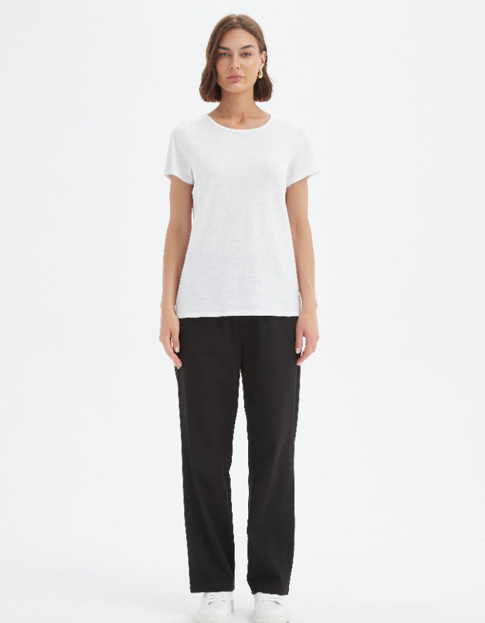 Woman wearing a white t-shirt and black pants on a white background