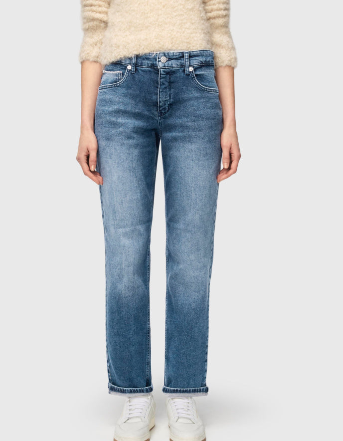 Person wearing light blue jeans on a white background