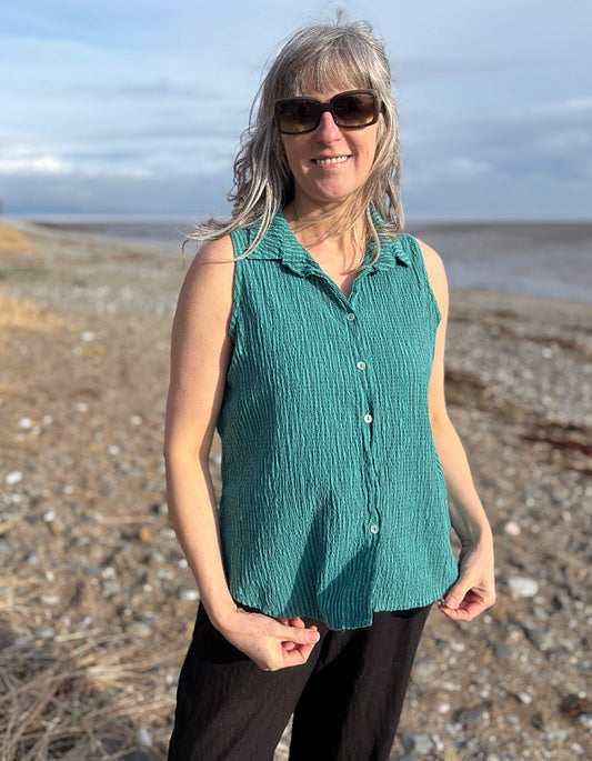woman wearing teal sleeveless shirt on a beach