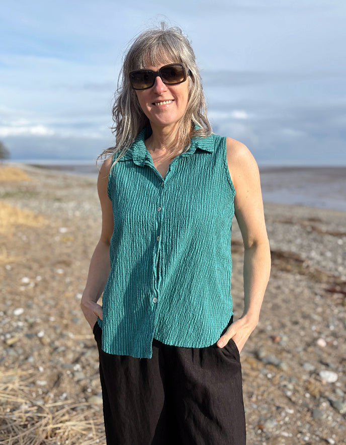 woman wearing teal sleeveless shirt on a beach