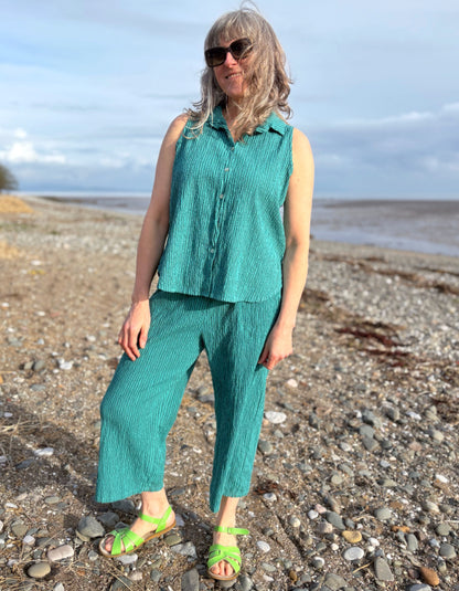 woman wearing teal sleeveless shirt on a beach