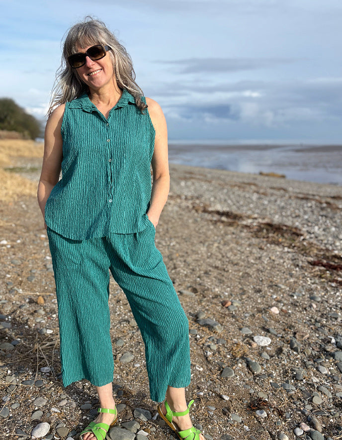 woman wearing teal sleeveless shirt on a beach