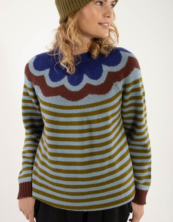 Woman wearing a colorful sweater with a white background