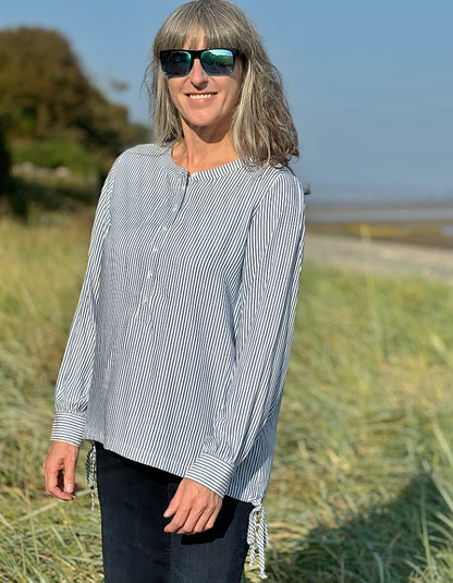 blue and white stripe blouse with half button placket fastening at the front and side drawstring tie