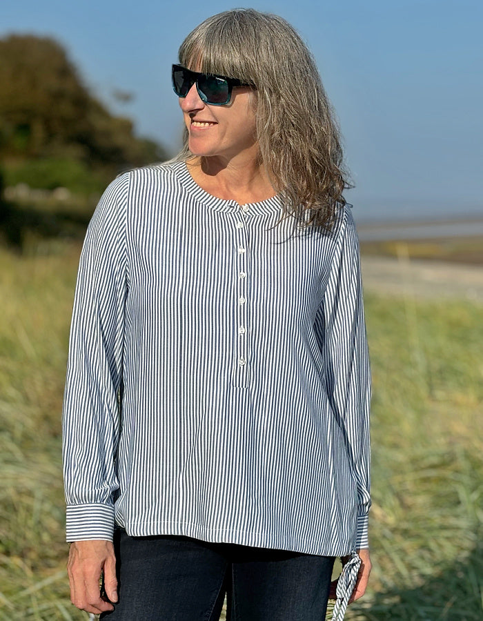 blue and white stripe blouse with half button placket fastening at the front and side drawstring tie