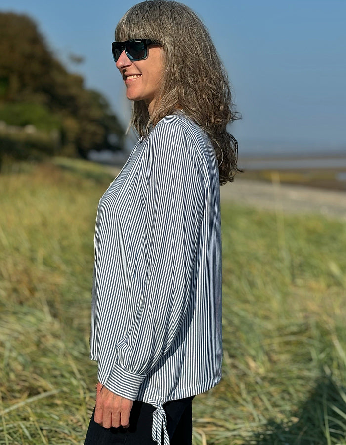 blue and white stripe blouse with half button placket fastening at the front and side drawstring tie