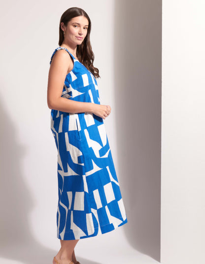 Woman wearing a blue and white patterned dress against a plain background