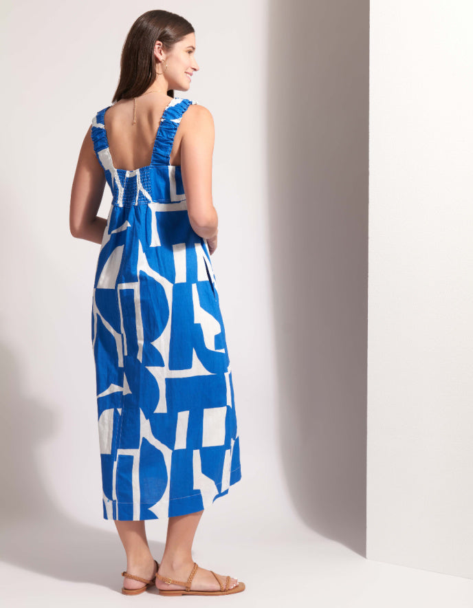 Woman wearing a blue and white patterned dress against a plain background