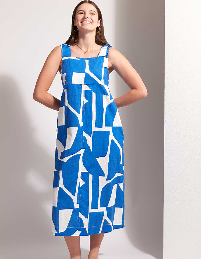 Woman wearing a blue and white patterned dress against a plain background