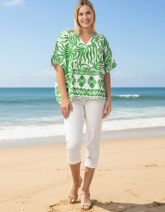 woman wearing green and white wide fit top on a beach