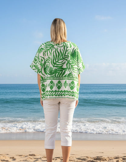 woman wearing green and white wide fit top on a beach