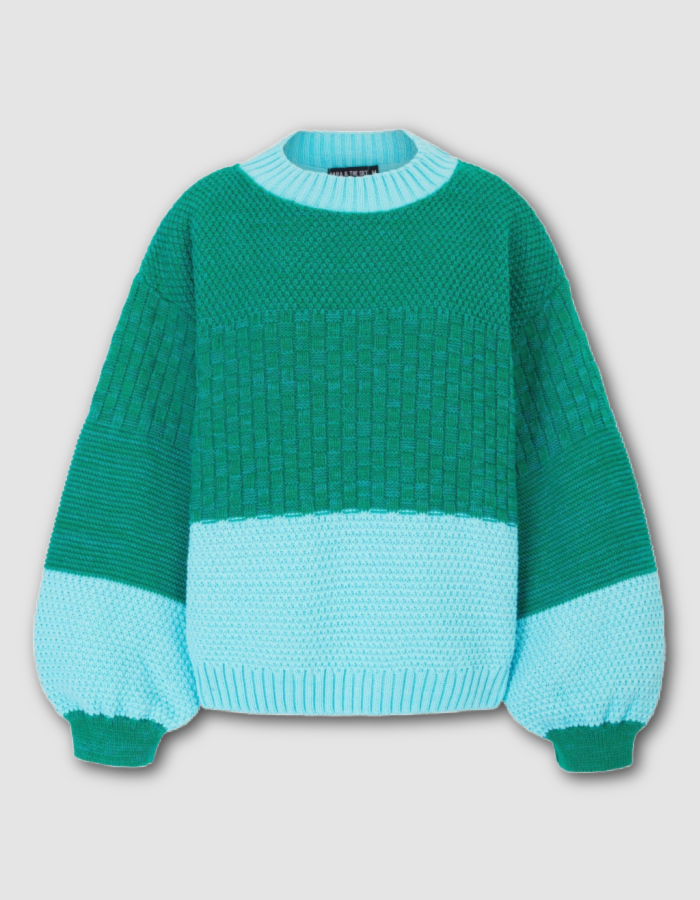 A color-block knit sweater in shades of green and light blue, featuring a textured basketweave pattern on the chest and sleeves, a solid knit lower section, and a ribbed crew neck and cuffs.