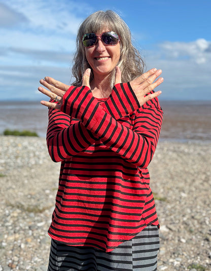 Woman wearing a red and black striped fleecy line long sleeve T shirt on a beach