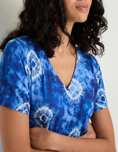 woman wearing a midi length tie dyed blue and white jersey bubble dress