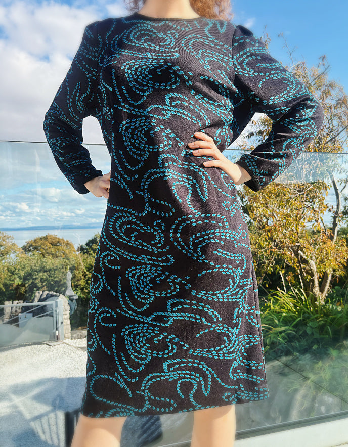 knee length black dress with pockets and blue geometric pattern