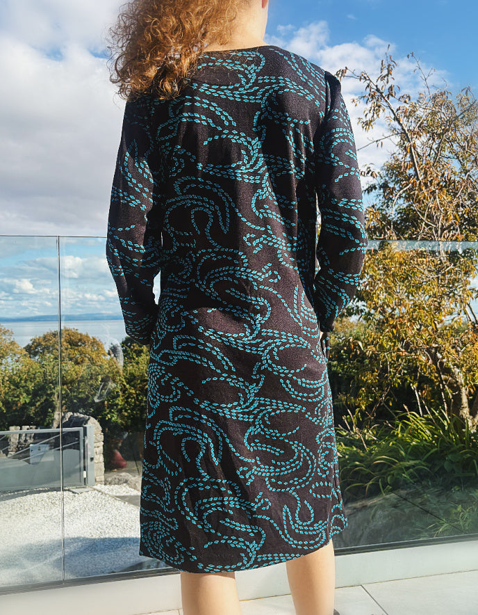 knee length black dress with pockets and blue geometric pattern