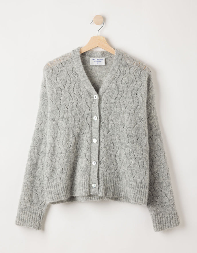 Gray knitted cardigan on a hanger against a white background