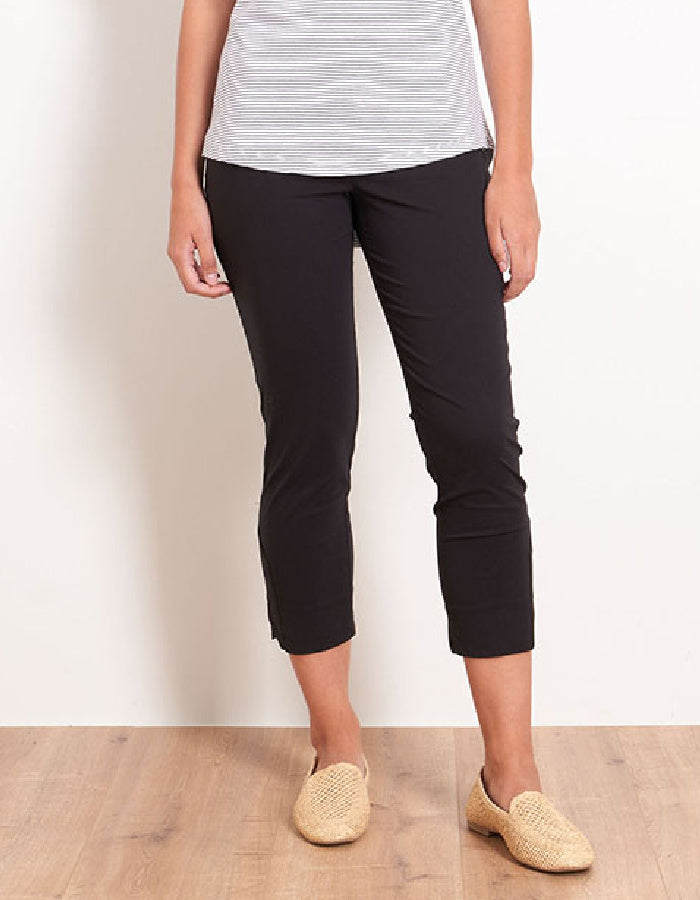 Person wearing black capri pants and a striped shirt on a plain background