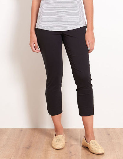 Person wearing black capri pants and a striped shirt on a plain background