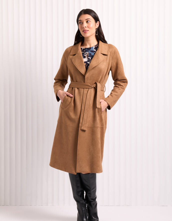 Woman wearing a brown trench coat with a white background