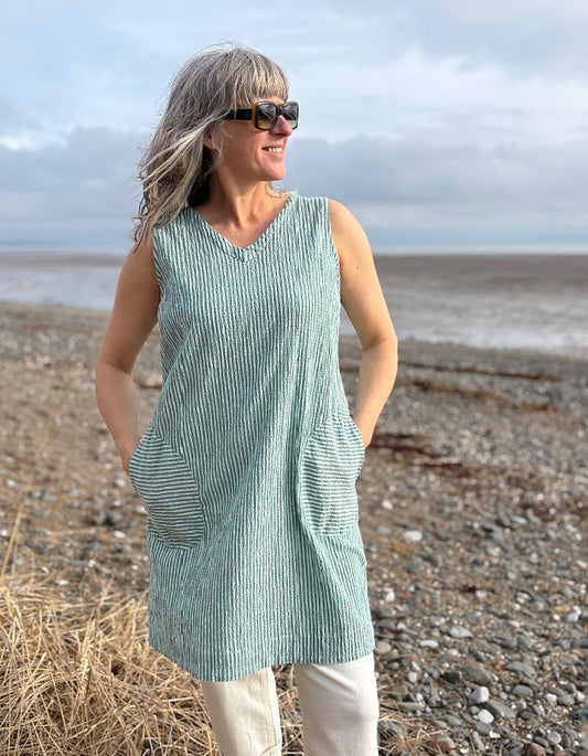 woman wearing mint striped tunic dress with cream jeans