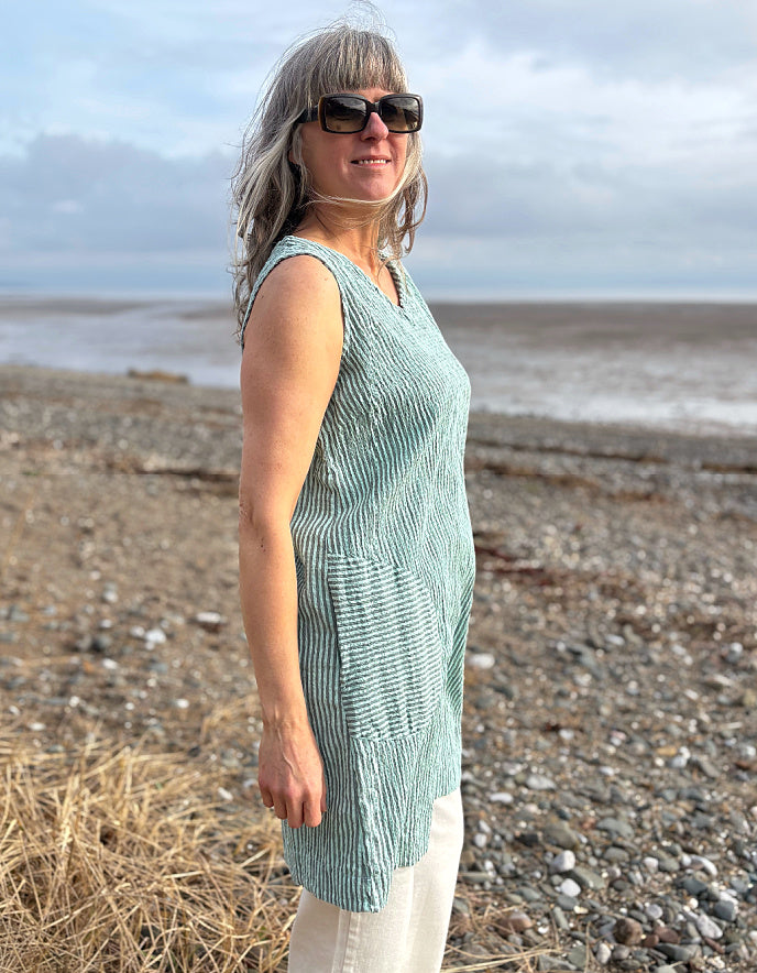 woman wearing mint striped tunic dress with cream jeans