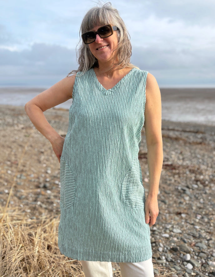 woman wearing mint striped tunic dress with cream jeans