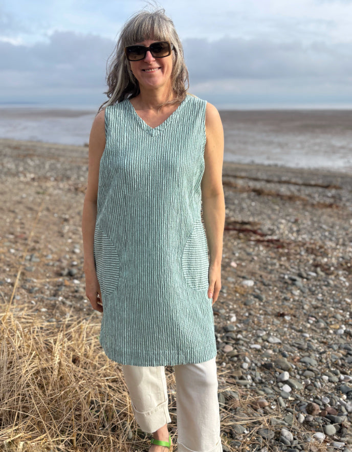 woman wearing mint striped tunic dress with cream jeans