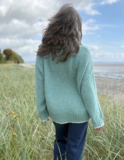 woman wearing a pale blue cosy turtle neck sweater with jeans