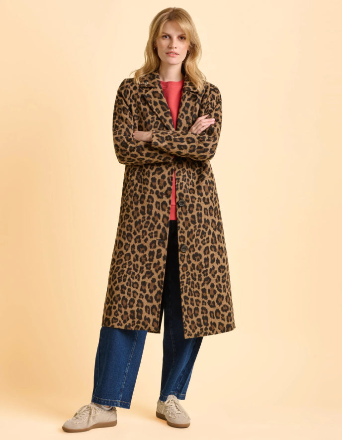 Woman wearing a leopard print coat on a beige background
