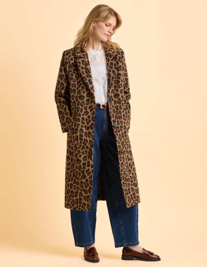 Woman wearing a leopard print coat on a beige background