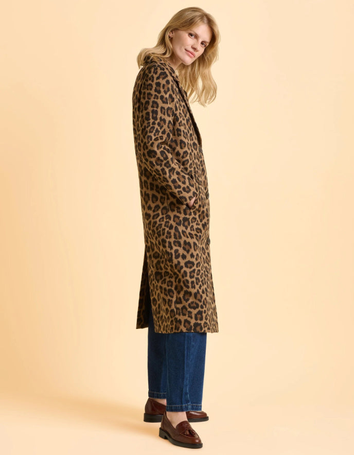 Woman wearing a leopard print coat on a beige background