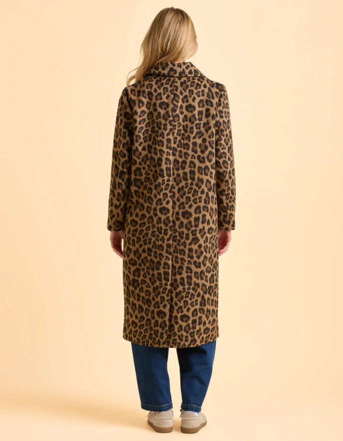 Person wearing a leopard print coat on a beige background