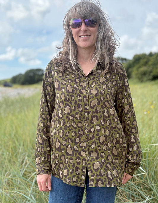 Person wearing a leopard print shirt in a field