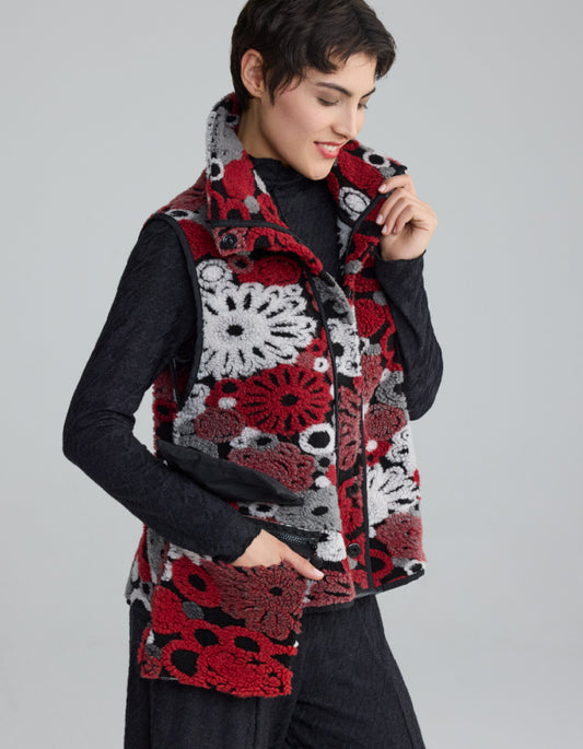 Woman wearing a colorful crochet vest on a gray background