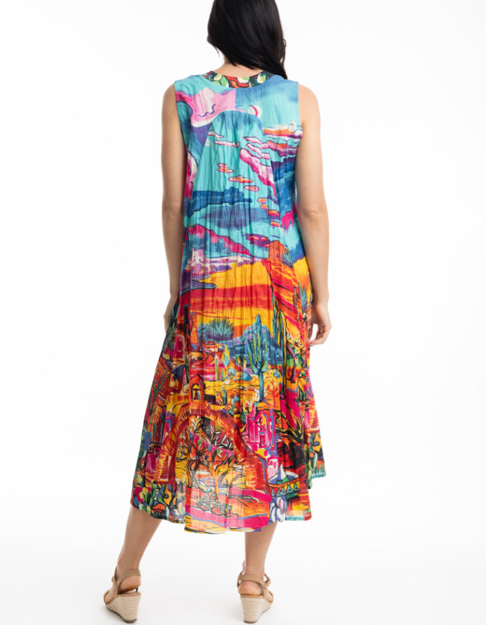 sleeveless sun dress made from crinkle cotton with v neckline and pockets and featuring a brightly coloured Mexican themed print