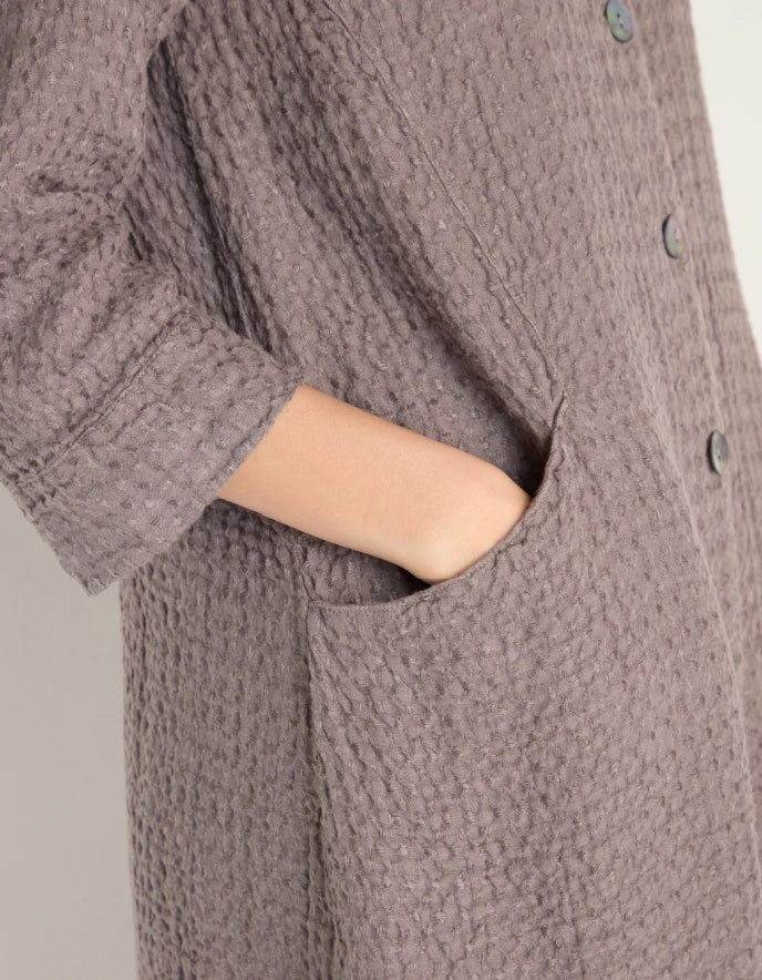 lady wearing mushroom coloured linen textured duster style coat