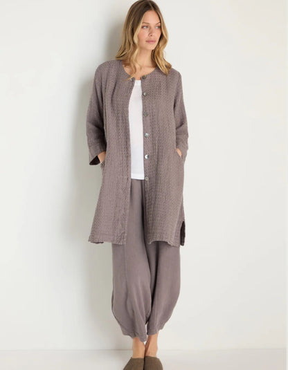 lady wearing mushroom coloured linen textured duster style coat