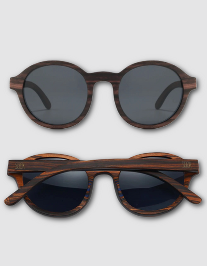 Two views of round sunglasses with a dark brown wood grain frame and dark lenses, shown from the front and side on a light gray background.